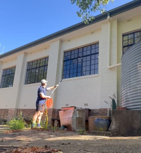 Aidan from Rivergum Services cleaning windows on a Sydney Eastern Suburbs property with a water-fed pole